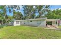 Exterior view of a light gray home with a well-manicured lawn at 4818 Huron St, Zephyrhills, FL 33541