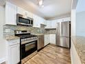 Updated kitchen with stainless steel appliances, granite counters, and modern white cabinets at 5980 80Th N St # 408, St Petersburg, FL 33709
