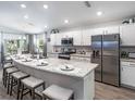 Modern kitchen featuring stainless steel appliances, a granite countertop island with seating, and stylish white cabinets at 6926 161St E Ter, Parrish, FL 34219
