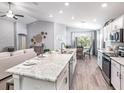 Bright, open-concept kitchen with stainless steel appliances, granite countertops, and an island bar with seating at 6926 161St E Ter, Parrish, FL 34219