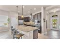 Open kitchen with stainless steel appliances, granite countertops, and a breakfast bar at 11825 Frost Aster Dr, Riverview, FL 33579