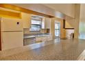 Efficient kitchen with granite countertops and white appliances, ideal for meal preparation at 12212 Hidden Brook Dr, Tampa, FL 33624
