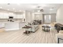Bright and open-concept living space with wood flooring, modern furniture, and seamless flow to the kitchen at 2422 White Ladyfish Rd, Wimauma, FL 33598