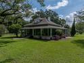 Charming two-story home featuring a welcoming front porch and mature landscaping on a sunny day at 2802 Midway Rd, Plant City, FL 33565