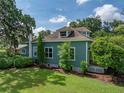 Side view of a charming home showcasing the lush green lawn and mature trees surrounding the property at 2802 Midway Rd, Plant City, FL 33565