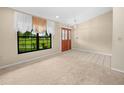 Bright entryway with tile and carpet flooring, light-colored walls, and large windows overlooking a landscaped lawn at 2815 Kebs Ln, Plant City, FL 33565