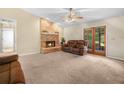 Cozy living room with a brick fireplace, carpeted floors, and double glass doors to outdoor area at 2815 Kebs Ln, Plant City, FL 33565
