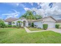 Attractive single-Gathering home with lush green lawn and meticulously maintained landscaping with mature palm tree at 4223 Amber Ridge Ln, Valrico, FL 33594