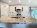 Modern kitchen featuring stainless steel appliances, stylish backsplash, and a large center island with a sink at 4592 Crabapple Ave, North Port, FL 34287