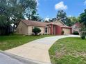A charming single-Gathering home with a well-manicured lawn and a long driveway leading to the attached garage at 8050 Eacon Ct, Hudson, FL 34667