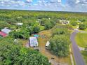 Aerial perspective of the property reveals its sprawling grounds, neighboring homes, and the surrounding wooded area at 12410 Myrtlewood Dr, Riverview, FL 33579
