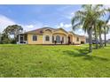 House exterior with palm trees and lush lawn at 12209 Cotorro Ave, North Port, FL 34287