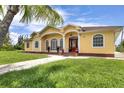 Beautiful one-story home with a welcoming front porch and lush landscaping at 12209 Cotorro Ave, North Port, FL 34287