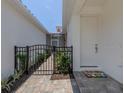 Side yard with gate and pathway leading to the house at 117 Clifton Way, Venice, FL 34292