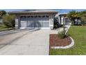 View of the driveway and garage of a single story home with gray exterior at 3819 Ragen St, North Port, FL 34287