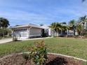 Single-story home with gray exterior, screened-in porch and landscaped yard at 3819 Ragen St, North Port, FL 34287