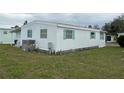 White single-wide manufactured home with a covered carport and partially fenced yard at 626 Cervina Dr, Venice, FL 34285