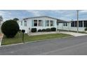 Mobile home with covered carport, landscaping, and screened porch at 626 Cervina Dr, Venice, FL 34285