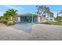 Pink home with covered patio, carport, and tropical landscaping at 7037 Duke St, Englewood, FL 34224