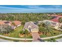 One-story house with tile roof, paver driveway, and lush landscaping at 5674 Blue Heron Cir, North Port, FL 34287