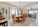 Bright dining room with chandelier, natural light, and stylish furniture, perfect for entertaining guests at 11065 Barnsley Dr, Venice, FL 34293