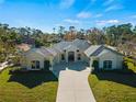 Single-story home with beige exterior, large driveway and lush lawn at 11801 De Herreda Dr, North Port, FL 34287