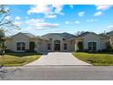 Single-story home with beige exterior, large driveway and lush lawn at 11801 De Herreda Dr, North Port, FL 34287