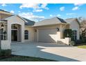 House exterior featuring a three-car garage and a double door entry at 11801 De Herreda Dr, North Port, FL 34287