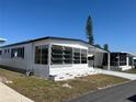 White single-wide mobile home with carport and landscaping at 213 Como Dr, Venice, FL 34285