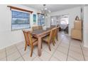 Bright dining room with a wooden table, chairs, and a modern chandelier at 5355 Kent Rd, Venice, FL 34293