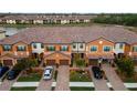 Aerial view of townhomes with tile roofs and landscaping at 20392 Lagente Cir, Venice, FL 34293