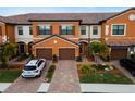 Orange two-story townhome with brown garage doors and landscaping at 20392 Lagente Cir, Venice, FL 34293