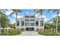 Elegant beachfront building featuring lush landscaping, gated entry, and classic architectural design for upscale coastal living at 361 Benjamin Franklin Dr # A, Sarasota, FL 34236
