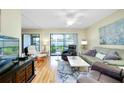 Living room with wood floors, comfortable seating, and sliding glass doors at 744 White Pine Tree Rd # 103, Venice, FL 34285
