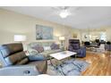 Living room with hardwood floors, recliner chairs, and a view to dining area at 744 White Pine Tree Rd # 103, Venice, FL 34285