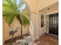 Front entry with arched entryway, palm tree, and bird statue at 205 Mestre Pl, North Venice, FL 34275