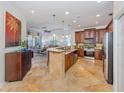 Open kitchen with island, stainless steel appliances, and wood cabinets at 205 Mestre Pl, North Venice, FL 34275