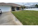Single story house with a white garage door and green lawn at 56 Princeton Rd, Venice, FL 34293