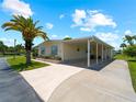 Mobile home exterior with carport and tropical landscaping at 490 Ashwood Dr, Venice, FL 34285