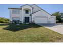 Two-story house with a three-car garage and manicured lawn at 14462 Fort Worth Cir, Port Charlotte, FL 33981