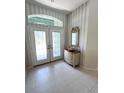 Bright entryway with double doors and antique dresser at 2454 Sonoma W Dr, Nokomis, FL 34275
