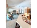 Open kitchen with breakfast bar and view into living room at 2454 Sonoma W Dr, Nokomis, FL 34275