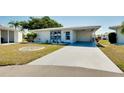 Front view of a single story home with carport and landscaped yard at 472 Circlewood Dr # L9, Venice, FL 34293