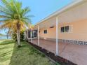 Mobile home exterior with carport, landscaping, and palm tree at 109 Lakeview Dr, North Port, FL 34287