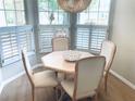 Bright dining area with white plantation shutters and a stylish light fixture creating an inviting atmosphere at 334 Melrose Ct, Venice, FL 34292
