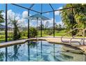 Relaxing in-ground pool area with umbrella and wrought iron fence featuring manicured greenery at 233 Fairway Rd, Rotonda West, FL 33947