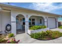 Inviting front porch with arched entryway, well-manicured landscaping, and a two-car garage at 8509 La Boca Ave, North Port, FL 34287