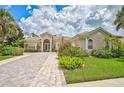 Single-Gathering home with brick paver driveway and lush landscaping at 4376 Corso Venetia Blvd, Venice, FL 34293