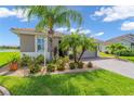 Charming single-story home boasts a landscaped front yard with palm trees and a paver driveway at 9263 Peregrine Way, North Port, FL 34287