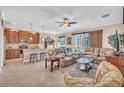 Spacious living room open to kitchen with tile floors, ceiling fan and sliding doors to the lanai at 9263 Peregrine Way, North Port, FL 34287